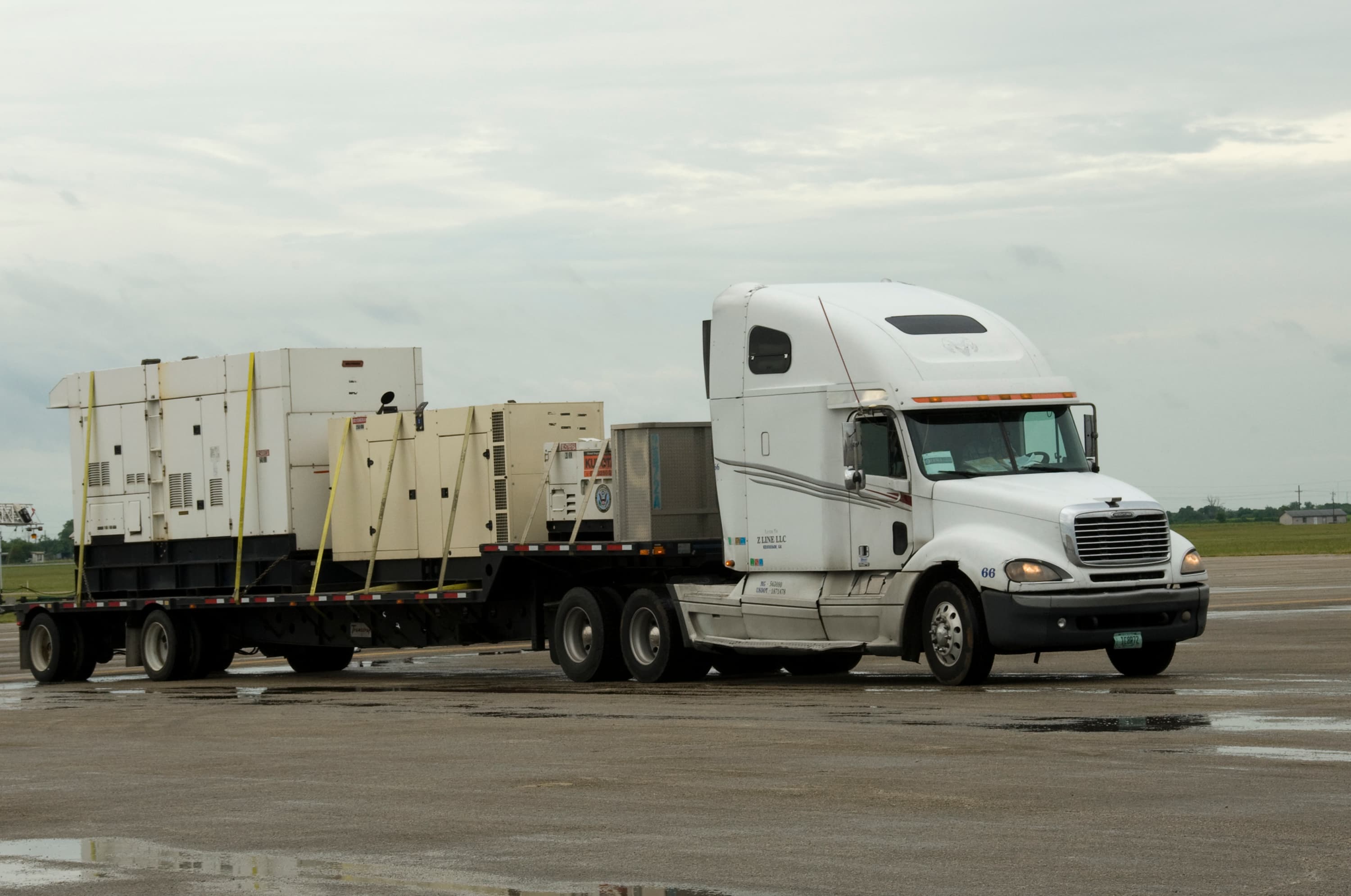 Flatbed semi truck hauling mobile generators to an emergency response staging area