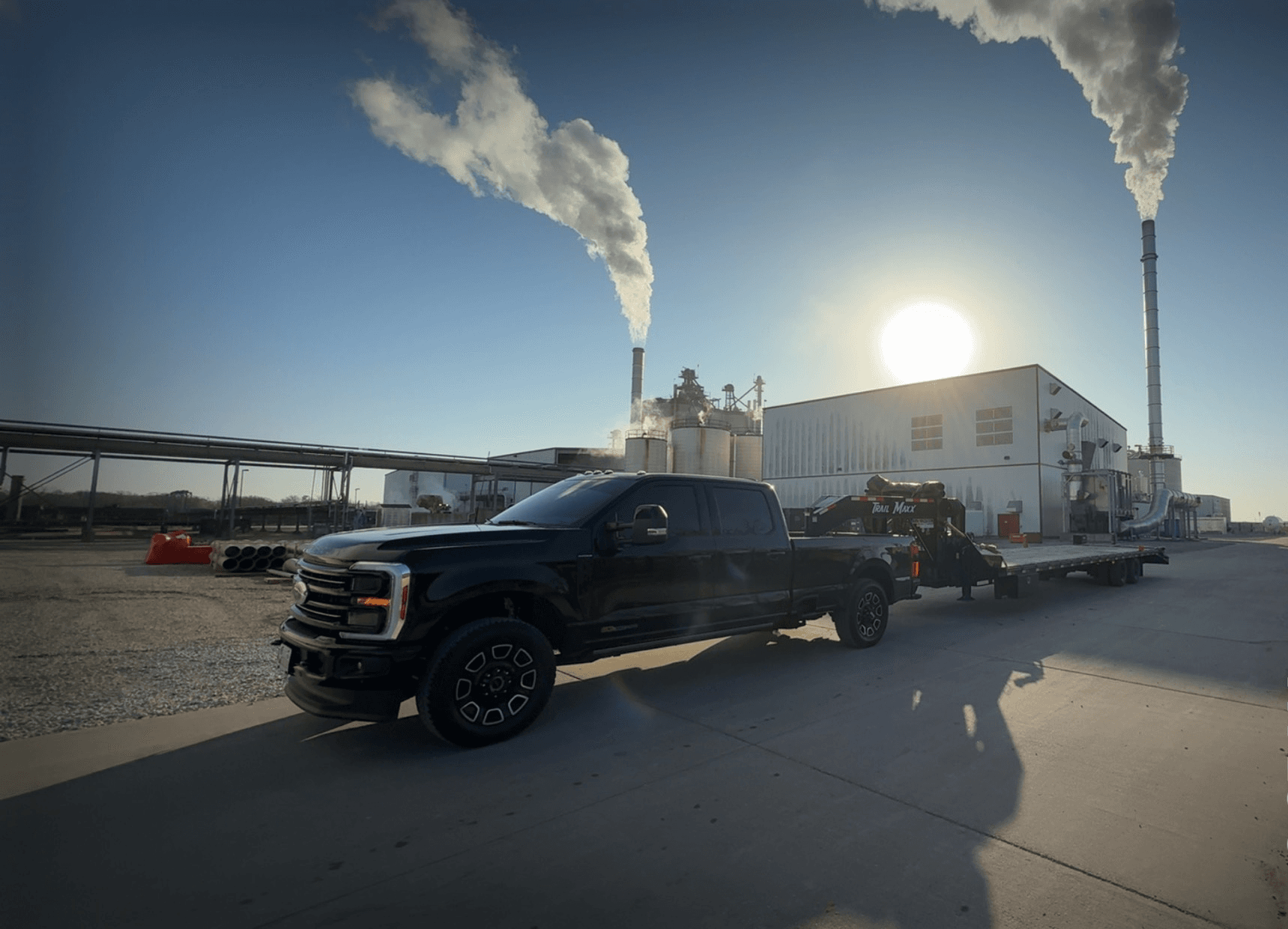 Ford pickup hauling equipment on a loaded power-tilt hotshot trailer